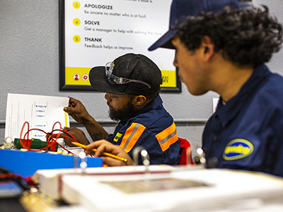 Two men working with wires at the Truck Care Academy