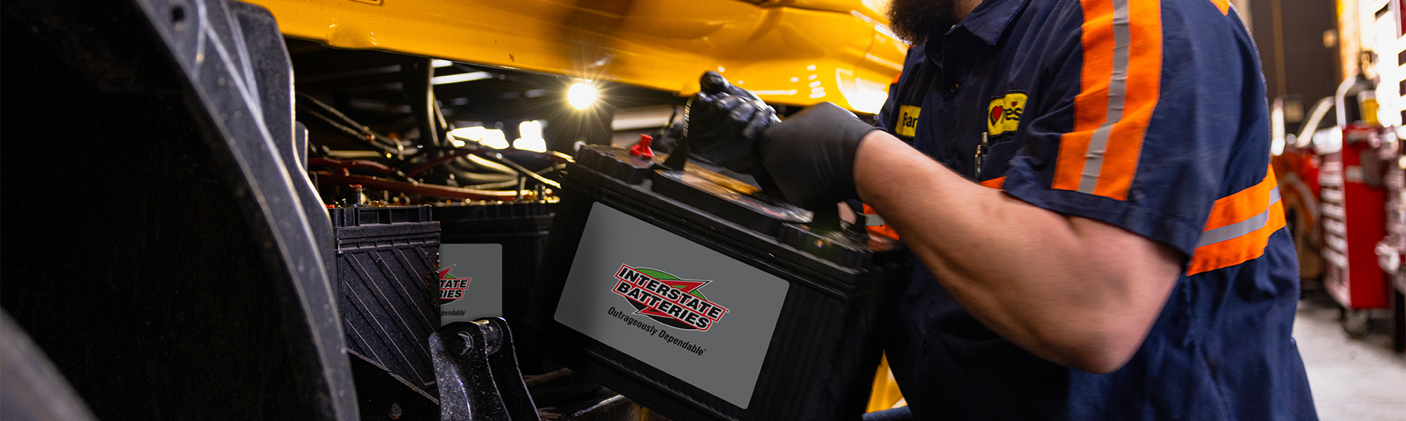 A Truck Care technician working with an Interstate Battery